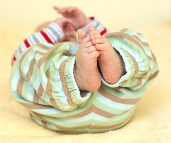 Lindos pies de bebé en pantalones rayados — Foto de Stock