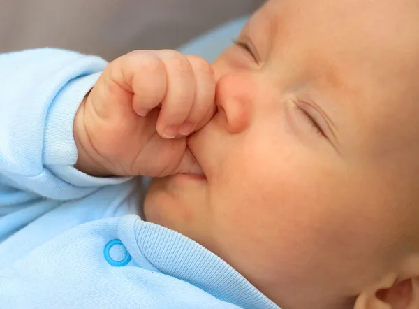 Bebé chico chupando el pulgar para quedarse dormido Imagen de archivo