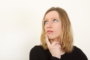 Portrait of young woman thinking and looking up clipart