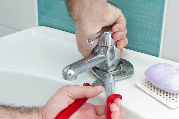 Loodgieter handen tightning loospijp met een tang — Stockfoto