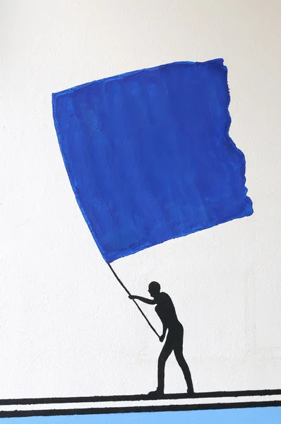 Osoba z dużą niebieską flagą — Zdjęcie stockowe