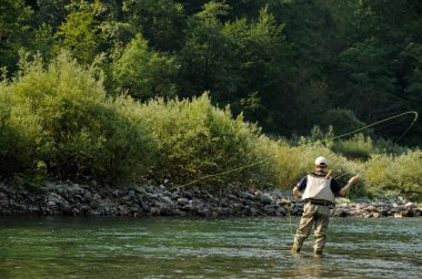 Fishing on the mountain river clipart