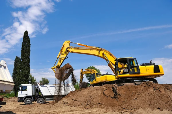 Excavator loading earth on truck — Stock Photo, Image