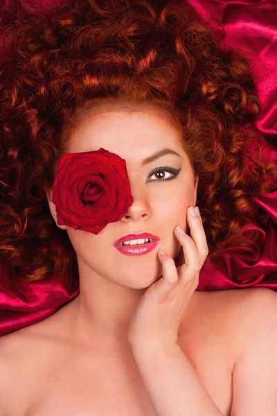 Wanita berambut merah dengan bunga di latar belakang tirai — Stok Foto