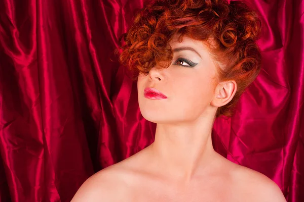 Femme aux cheveux roux sur fond de rideaux — Photo