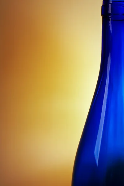Garrafa de vinho azul no fundo laranja — Fotografia de Stock