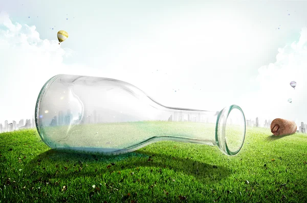Empty glass bottle on green grass — Stock Photo, Image