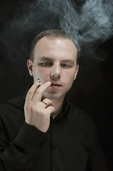 Young man smokes a cigarette — Stock Photo, Image