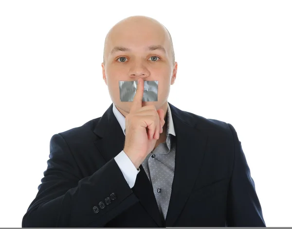Young businessman holding a finger to his mouth. — Stock Photo, Image