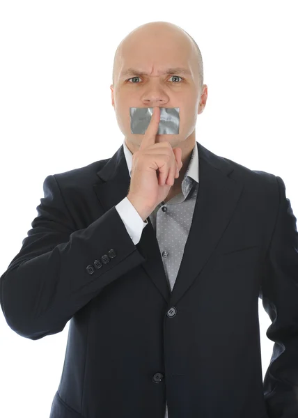 Young businessman holding a finger to his mouth. — Stock Photo, Image