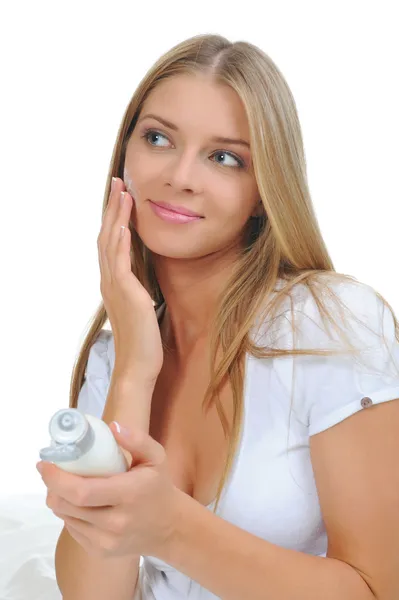 Beautiful woman applying cream on her cheek — Stock Photo, Image
