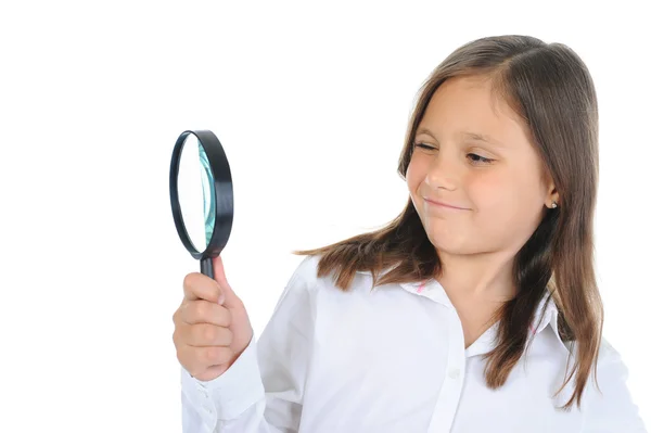 Girl looking through a magnifying glass — Stock Photo, Image
