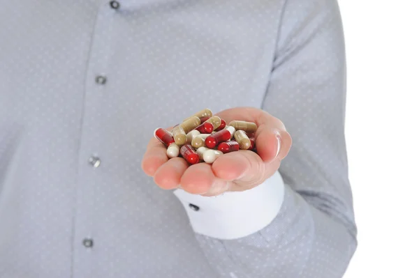 Comprimidos rojos y blancos en mano masculina — Foto de Stock