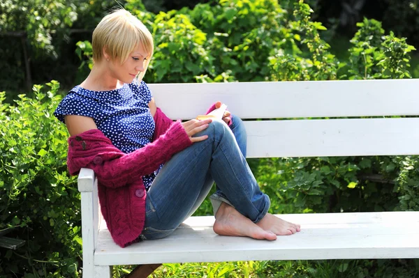 Park yerinde kitap okuyan bir kadın. — Stok fotoğraf