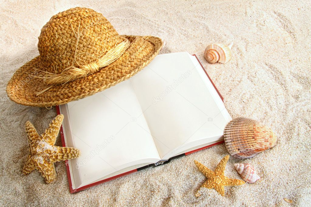 Book with straw hat and seashells in sand