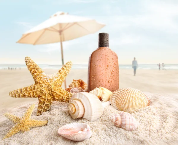 Zonnecrème en schelpen op het strand — Stockfoto