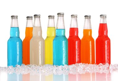 Bottles of multi-color drinks with ice on white