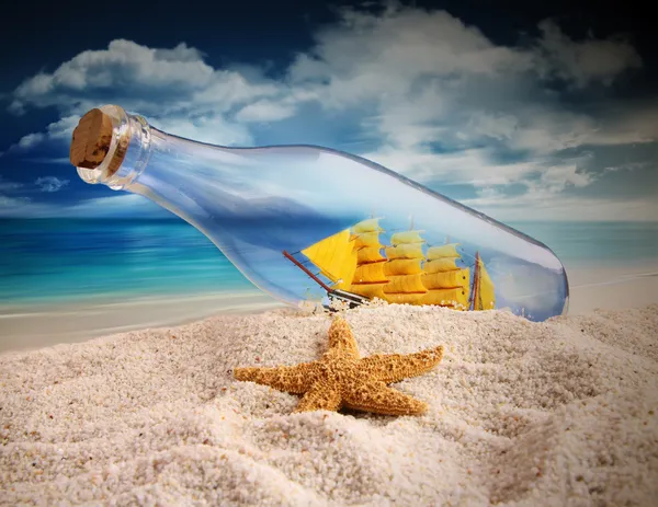 Navio em uma garrafa deitada na areia — Fotografia de Stock