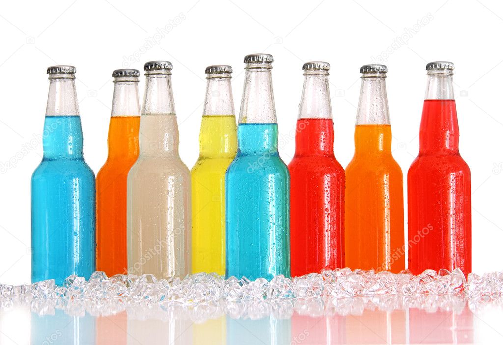 Bottles of multi-color drinks with ice on white
