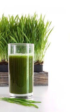 Glass of wheatgrass on white clipart