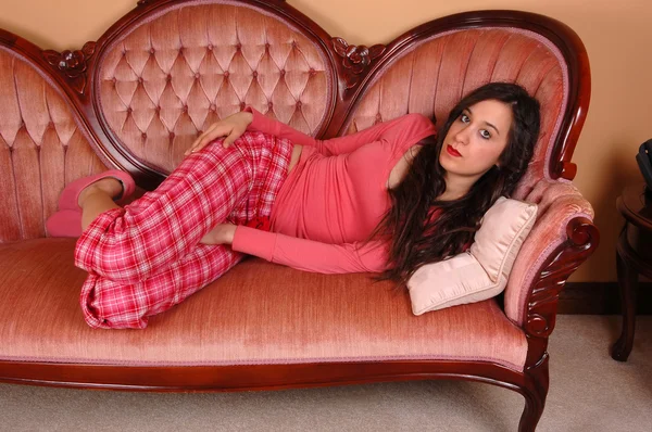 Dívka v pyjama v pohovce. — Stock fotografie