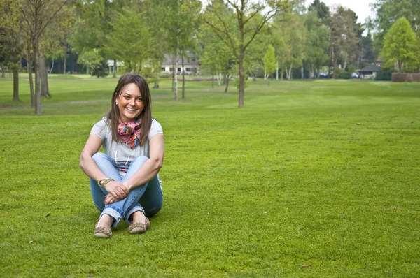 Mujer sentada en una hierba verde —  Fotos de Stock