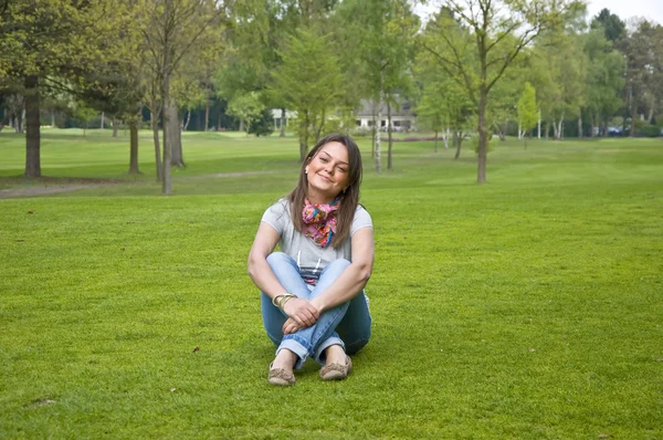 Kvinna sitter på en grön gräs — Stockfoto