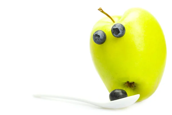 Broma manzana con ojos y una cuchara con arándanos aislados en wh — Foto de Stock