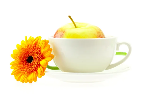 Apple in a cup and a flower isolated on white — Stock Photo, Image