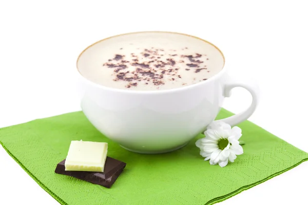 杯卡布奇诺咖啡、 巧克力和一张餐巾纸上的花 — 图库照片