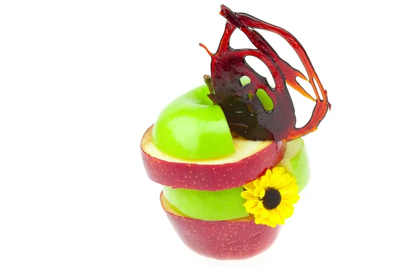Manzanas en rodajas con caramelo y una flor aislada en blanco — Foto de Stock