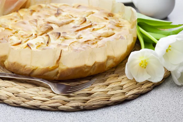 Stock image Apple pie, fork and tulips on a woven mat