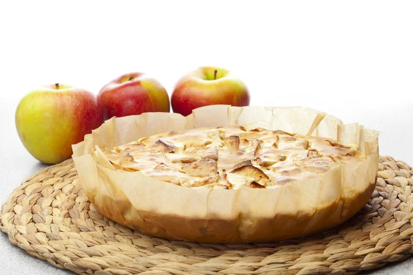 Яблочный пирог и яблоко на плетеном коврике — стоковое фото