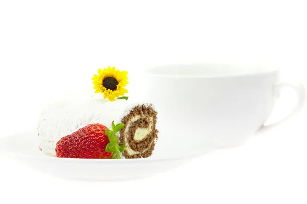 Кексовый рулет, клубника и цветок на тарелке, изолированной на белом — стоковое фото