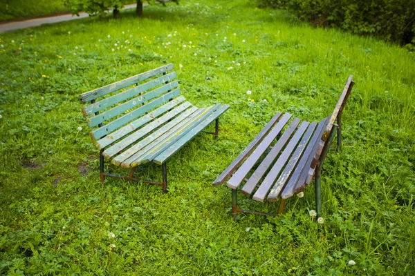 緑の芝生の背景に 2 つのベンチ — ストック写真