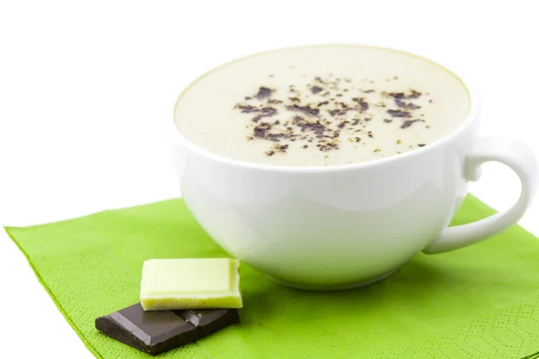 Чашка капучино, шоколад на салфетке — стоковое фото