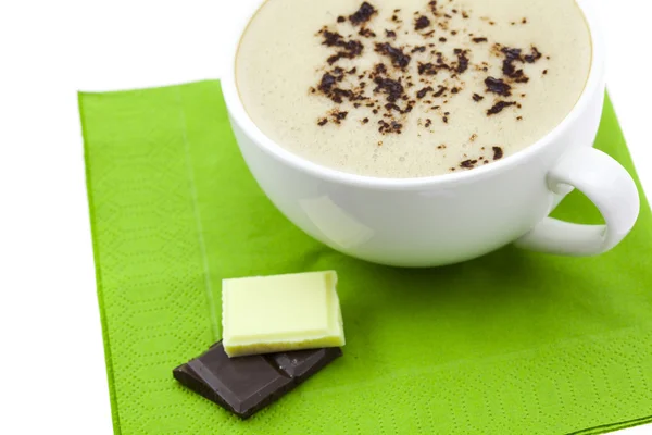Kopje cappuccino, chocolade en bloem op een servet — Stockfoto