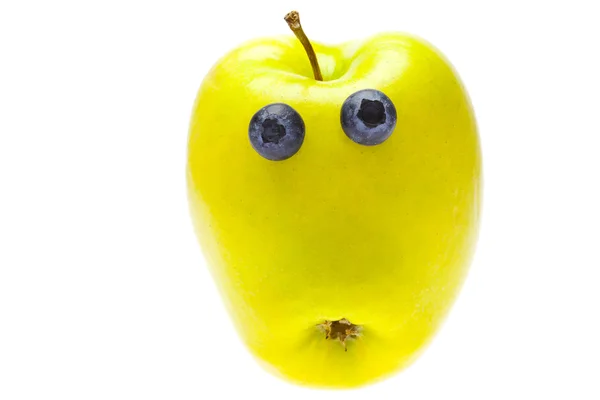 Grüner Apfel mit Augen aus Blaubeeren isoliert auf weiß — Stockfoto