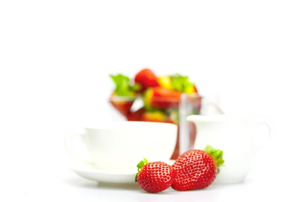 Cup a jahody ve skleněné mísy izolované na bílém — Stock fotografie