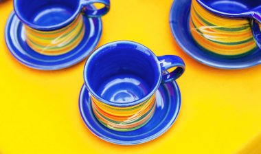 Ceramic cups on a yellow background clipart