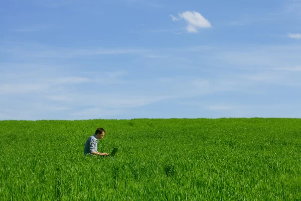 Genç adam bir dizüstü bilgisayar açık havada kullanma — Stok fotoğraf