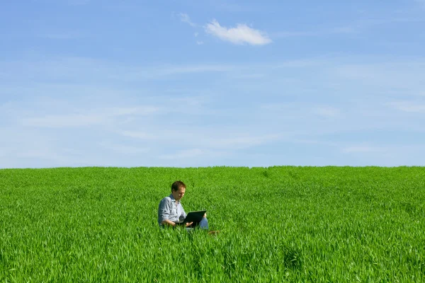 Jonge man met behulp van een laptop in de buitenlucht — Stockfoto
