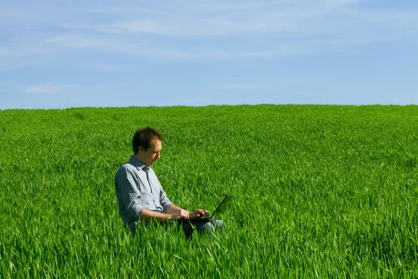 Hombre joven usando un ordenador portátil al aire libre —  Fotos de Stock