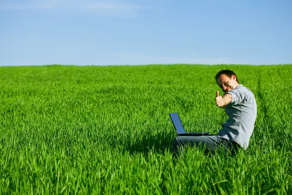 Ung man med en laptop utomhus — Stockfoto