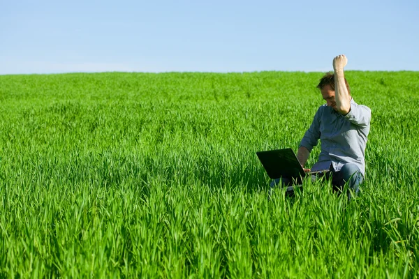 Hombre joven usando un ordenador portátil al aire libre — Foto de Stock