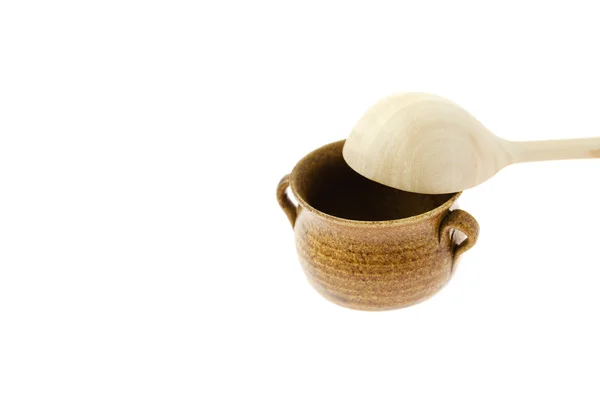 Pequeno jarro com uma colher de madeira isolada em branco — Fotografia de Stock