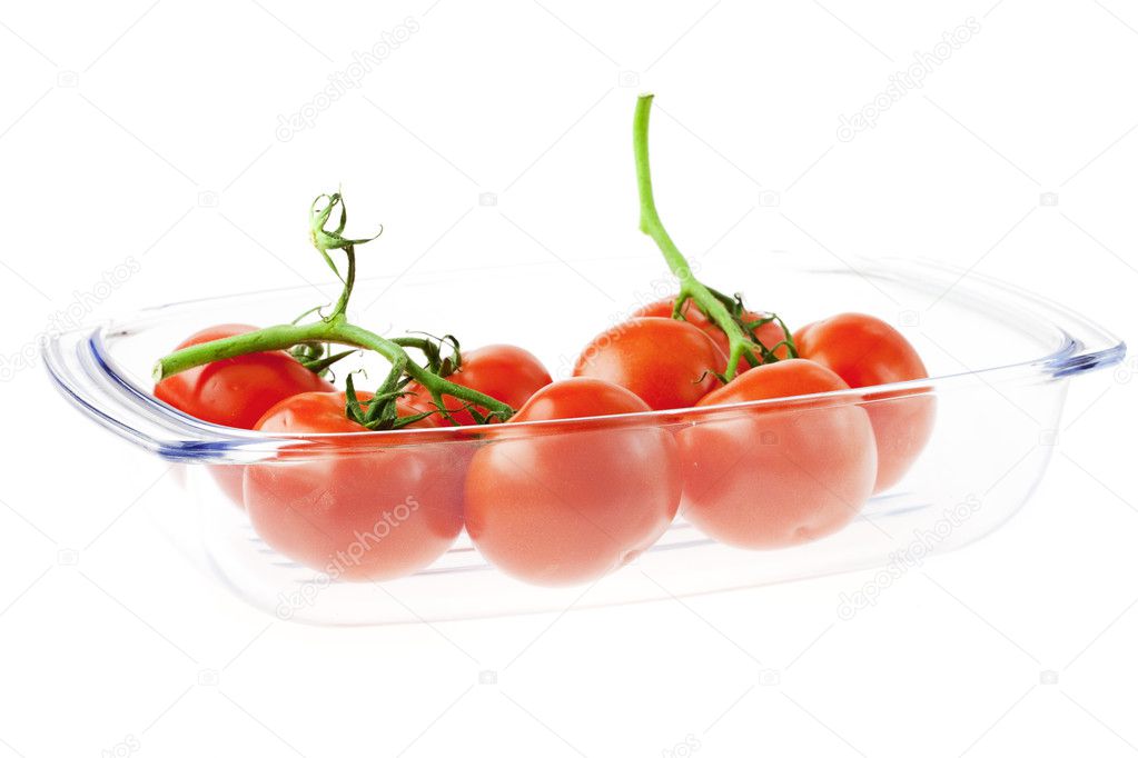 A bunch of tomatoes in a glass isolated on white