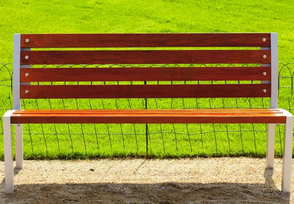 Bänk mot bakgrund av grönt gräs — Stockfoto