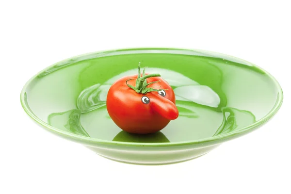 Tomate con una nariz en el plato y el verde aislado en blanco — Foto de Stock