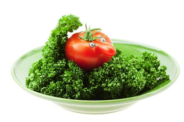 Tomate mit Nase auf grünem Teller isoliert auf weißem Teller — Stockfoto